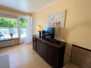 a living room with a television on a dresser at Panoramic App C02-1 in Sierksdorf