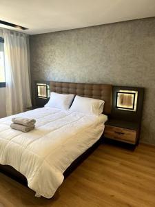 Best location, 2 minute to beach في الدار البيضاء: غرفة نوم بسرير كبير مع شراشف بيضاء