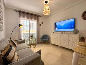 a living room with a couch and a flat screen tv at Casa Playa de Garrucha in Garrucha