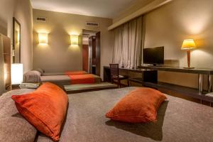 a hotel room with two beds and a television at Gran Hotel Argentino in Buenos Aires