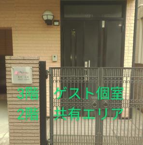 ein Schild an der Vorderseite eines Hauses mit Tor in der Unterkunft Noriko's Home - Vacation STAY 13624 in Kawasaki