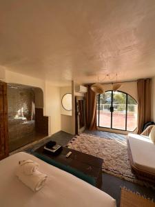 Cette chambre comprend un lit, un bureau et une fenêtre. dans l'établissement MORO Marrakech Boutique Hôtel, à Marrakech