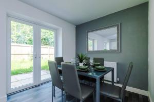 a dining room with a table with chairs and a mirror at Penny Bridge Home From Home in Saint Helens