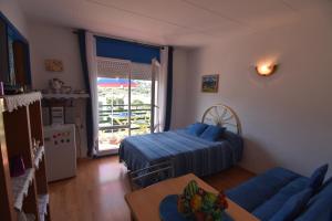 sala de estar con sofá, cama y ventana en RNET - Mas Oliva Studio, piscina, terraza, en Roses