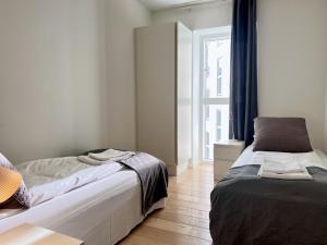 a bedroom with two beds and a window at Cozy New Apartment In Popular Area 2 in Copenhagen