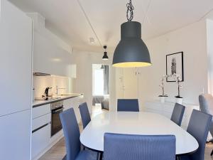 a kitchen and dining room with a white table and blue chairs at Cozy New Apartment In Popular Area 2 in Copenhagen