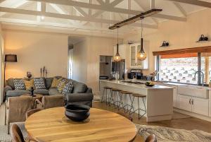 a living room with a couch and a table and a kitchen at Fairfax Cottage in Nottingham Road