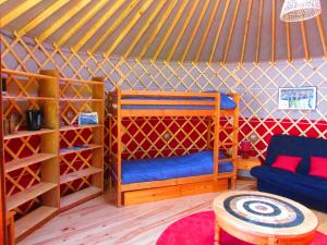 Zimmer mit einem Bett und einem Tisch in einer Jurte in der Unterkunft Maurienne Outdoor - Nuit insolite en Yourte en Savoie in Saint-Georges-des-Hurtières