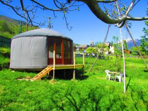 uma tenda com uma mesa e um banco num campo em Maurienne Outdoor - Nuit insolite en Yourte en Savoie em Saint-Georges-des-Hurtières