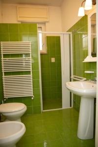baño verde con aseo y lavamanos en RizzoRelax B&b io mammata e tu en Capilungo