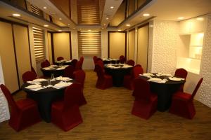 a dining room with tables and red chairs at Grand Legacy Hotel Doha in Doha