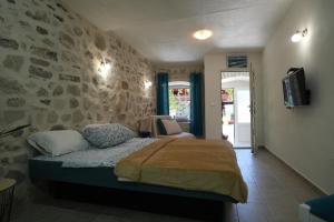 una camera con un letto e un muro in pietra di APARTMENTs VISIT PERAST a Perast