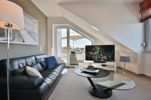 ein Wohnzimmer mit einem Sofa und einem TV in der Unterkunft Villa Seestern Villa Seestern Appartement 8 in Timmendorfer Strand