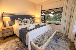 a bedroom with a large bed and a window at Fairfax Cottage in Nottingham Road