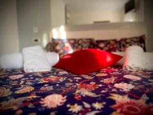 a bed with a red pillow on top of it at B&B da Mary in Matrice