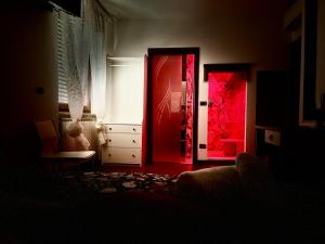 Cette chambre sombre dispose d'une porte rouge et d'une fenêtre. dans l'établissement B&B da Mary, à Matrice