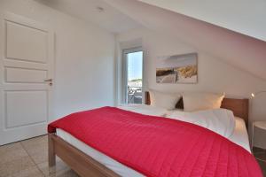 ein Schlafzimmer mit einem großen Bett mit einer roten Decke in der Unterkunft Villa Seestern Villa Seestern Appartement 8 in Timmendorfer Strand