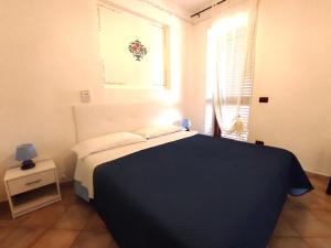 マルファにあるEoliano B&Bのベッドルーム1室(青い毛布、窓付)
