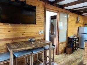 a living room with a large flat screen tv on a wooden wall at Vil'Ariane in Sainte-Marie