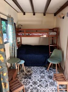 聖瑪麗的住宿－Vil'Ariane，一间卧室配有一张双层床和两把椅子