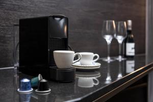 a counter with two coffee cups and wine glasses at Hotel ROMY by AMANO in Berlin