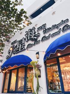 a restaurant with blue umbrellas on the side of a building at Qixingtan Xinghai B&B NO1044 & 2202 in Dahan