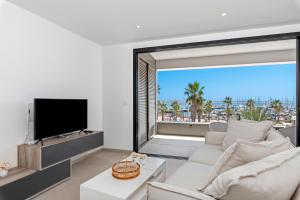 ein Wohnzimmer mit einem weißen Sofa und einem großen Fenster in der Unterkunft Spacious Wellness Beach apartment Junogu in San Pedro del Pinatar