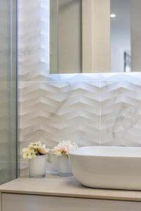 a bathroom with a sink and two vases with flowers at Elegance Apartment Junogu in San Pedro del Pinatar