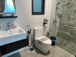 a bathroom with a toilet and a shower and a sink at Home Abroad 1 Jazz Suites Vivacity in Kuching +9 photos