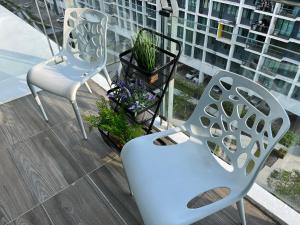 a balcony with two chairs and flowers on a building at Home Abroad 1 Jazz Suites Vivacity in Kuching