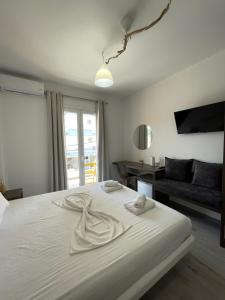 1 dormitorio con 1 cama blanca y sala de estar en Orchard Retreat, en Himare