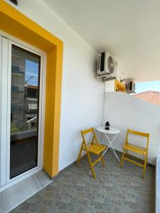 a small balcony with two chairs and a table at Orchard Retreat in Himare