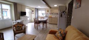 a living room with a couch and a kitchen at Gîte Des Huttes in Bain-de-Bretagne