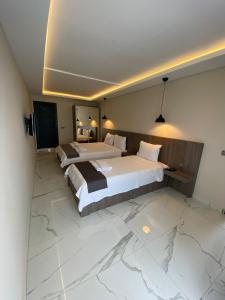 Habitación de hotel con 2 camas y suelo de mármol. en Tuna BUTİK OTEL, en Bodrum City