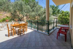 a patio with tables and chairs on a balcony at Petra Mare Apartments in Alyki