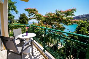 a balcony with a table and a view of the water at Petra Mare Apartments in Alyki