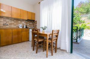 a kitchen with a table and chairs and a window at Petra Mare Apartments in Alyki