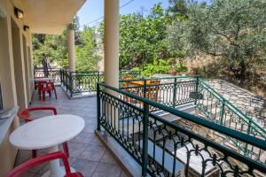 a balcony with a table and chairs and trees at Petra Mare Apartments in Alyki