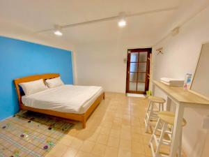 1 dormitorio con cama y pared azul en iTalay Krabi en Ban Suan