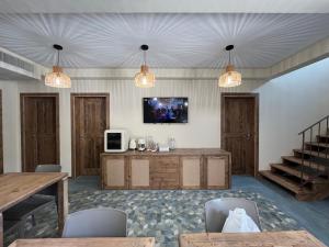 a living room with two lights and a tv on the wall at BnB Il Grecale in Lacona