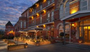 um edifício com uma mesa e guarda-chuva fora dele em The Address Cork (formerly Ambassador Hotel & Health Club) em Cork
