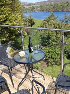 una botella de vino sentada en una mesa en una terraza en Castle View Apartment, en Dunvegan