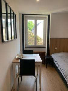 una stanza con un tavolo, un letto e una finestra di Au coeur de la ville a Bourges
