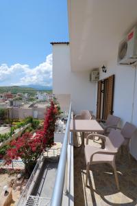 een balkon met een tafel en stoelen en uitzicht bij Vila Genci in Ksamil
