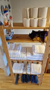 a shelf with a bunch of towels and shoes at Vindsvåning i Simrishamn in Simrishamn