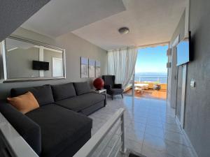 - un salon avec un canapé et une vue sur l'océan dans l'établissement Apartamento Naranja, incredible ocean view, à Puerto de Santiago