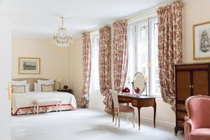 a bedroom with a bed and a desk with a mirror at Le Bristol Paris - an Oetker Collection Hotel in Paris