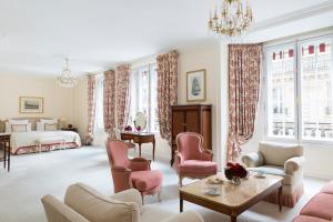 - un salon avec un lit, un canapé et des chaises dans l'établissement Le Bristol Paris - an Oetker Collection Hotel, à Paris