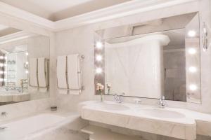 a bathroom with two sinks and a large mirror at Le Bristol Paris - an Oetker Collection Hotel in Paris