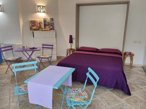 um quarto com uma cama roxa com cadeiras e mesas em Villa Alberto em Olbia